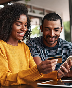couple with credit card on mobile phone